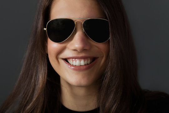 Beautiful woman portrait wearing sunglasses and smiling widely