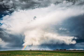Rainbow In Countryside Rural Field Spring Meadow Landscape Under Scenic Dramatic Sky