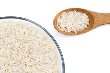 Close up of parboiled rice in glass bowl and wooden spoon on white background. Healthy food. Top view. High resolution product.