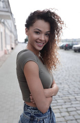 Young woman with afro hairstyle smiling in urban background