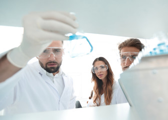 Obraz premium closeup.a group of scientists studying the liquid in the glass tube