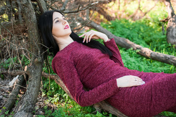 beautiful young brunette with long hair in a park on a spring in the middle of flowering trees in a...