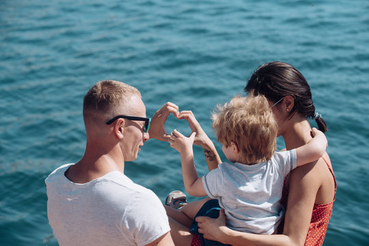 Mother and father with son swim at sea beach. Child with father and mother. Family travel with kid on mothers or fathers day. Love and trust as family values. Summer vacation of happy family.