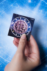 astrology concept with woman hand keeping a card with zodiac sign Libra 