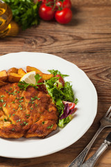 Chicken schnitzel, served with roasted potatoes and salad.
