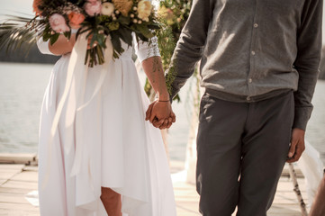 Man holding a hand of his bride on the wedding ceremony