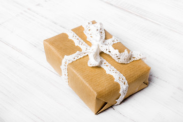 Obraz na płótnie Canvas Gift box with white bow on white wooden background, copy space