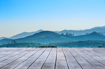 wooden table and beautiful landscape view of mountain ranges against with blue sky