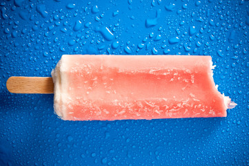 a strawebrry ice lolly over background with drops of water like summer concept