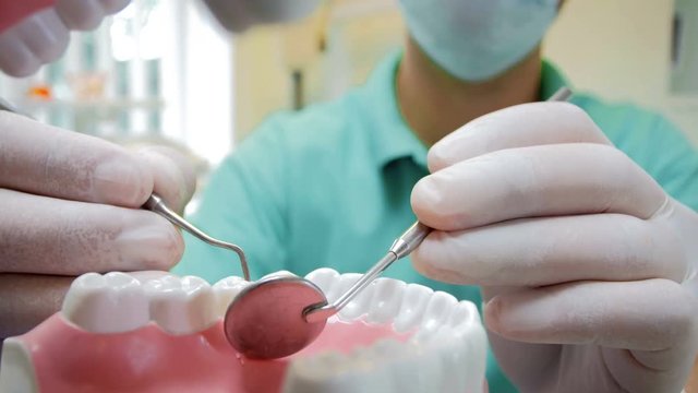 Closeup 4k video from inside of patient's mouth of doctor inspecting teeth