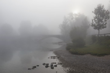 Obraz na płótnie Canvas Foggy morning scene in the Triglav national park, the bridge of Bohinj lake. Slovenia.