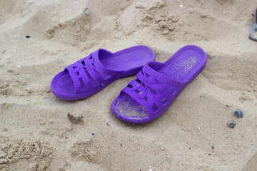 Fototapeta na wymiar purple slippers on the beach
