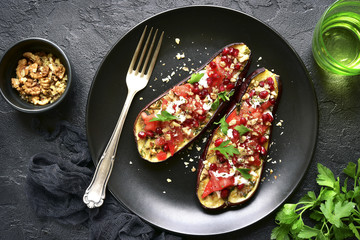 Grilled eggplant stuffed with tomatoes, nuts, pomegranate and yogurt dressing.Top view. - obrazy, fototapety, plakaty