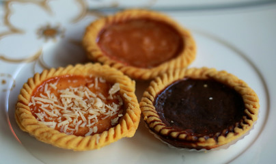 Custard tarts from Bali, Indonesia. Known as pie susu. Topping with chocolate, cheese and original. Made from flour, margarine, egg, sugar and milk.