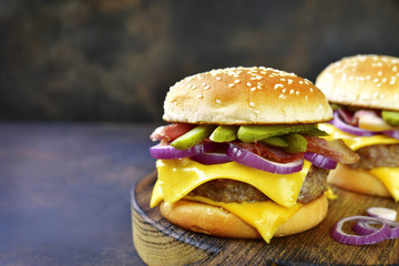 Cheeseburger with beef cutlet, fried bacon and pickled cucumber.