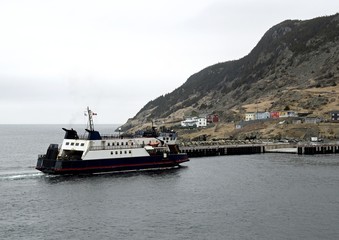 view across the bay towards the ferry approaching  the pier at Portugal Cove Newfoundland Canada