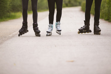 Close-up view of group of female legs on roller skates