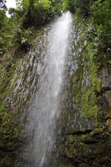 Obraz premium Cascata entre as rochas esverdeadas por musgo