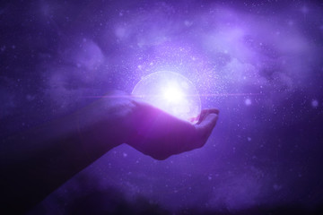 Hands holding the moon against the starry sky. Galaxy. Magic