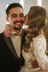 A young couple are basking, a girl is kissing a man. Emotions and smiles, enjoying the kiss.