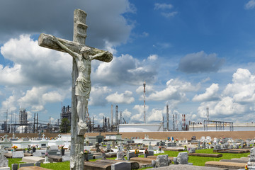 View of the Holy Rosary Cemetery in Taft, Louisiana, with a petrochemical plant on the background....