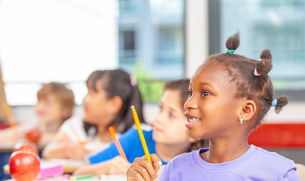 Mixed races classroom at elementary school with pupils following teacher lesson
