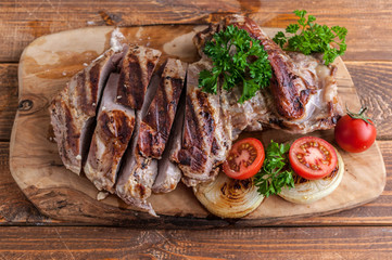 Grilled turkey fillet with spices, herbs and cherry tomatoes on a cutting board. Top view