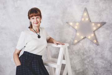 Senior woman standing against white wall