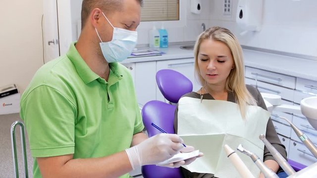 4k footage of dentist writing prescription to his female patient