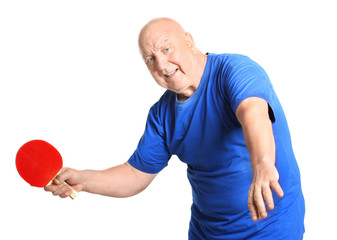 Senior man playing table tennis against white background