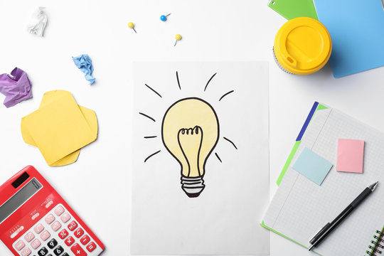 Workplace with drawing of light bulb and stationery on white background. Business trainer concept