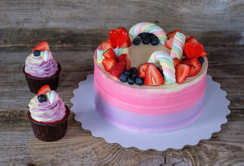 beautiful home made pink purple cake and cupcakes