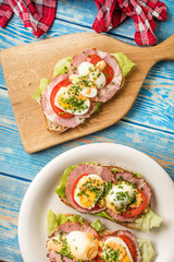 Sandwich with tomatoes, eggs and lettuce.