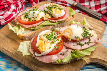 Sandwich with tomatoes, eggs and lettuce.