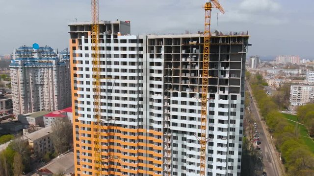 Construction site with a bird's eye in a megacity. Video shooting with drone. New house in a new residential complex. Flying over the construction site. New house next door in the city. 4K.