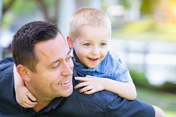 Fototapeta premium Young Caucasian Father and Son Having Fun At The Park