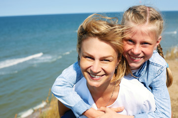 Fototapeta na wymiar Happy mother and daughter laughing together outdoors. Close up