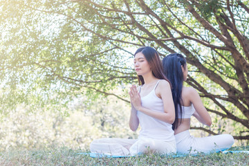 Young woman exercising and doing yoga in the garden with sunlight ,healthy concept
