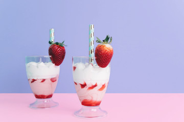 Milkshake with straw and strawberry.