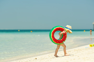 Toddler boy with swim ring on beach