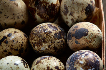Obraz premium Quail eggs in a box on a vintage wooden background, top view, selective focus.