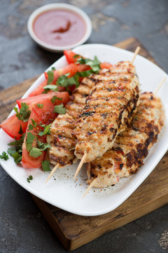Close-up of lula kebabs made of chicken meat and served with vegetables, studio shot, selective focus