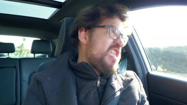 Man driving car making crazy unhappy faces expression