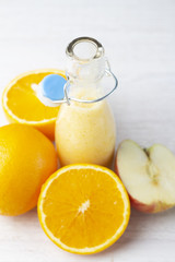 orange-apple smoothies and fruits on a white background close-up.