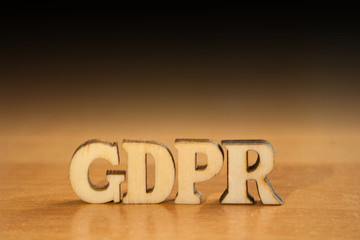 The word 'gdpr' made of wooden letters. wood inscription on table and dark black background