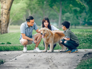 dog golden retriever playing with Asian family in park - 203697858