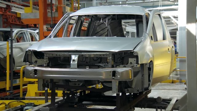 car body on moving stand on conveyor during assembly of automobiles