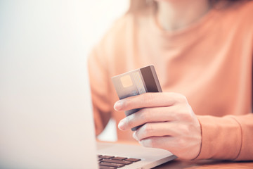 Fototapeta premium Woman hands holding credit card while using laptop. Online shopping concept.