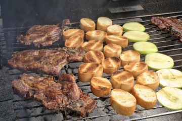 Tasty food, nutrition, culinary and outdoor concept: grilled meat with baguette and apple on a barbecue.