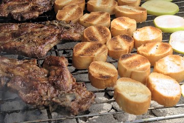Tasty food, nutrition, culinary and outdoor concept: grilled meat with baguette and apple on a barbecue.